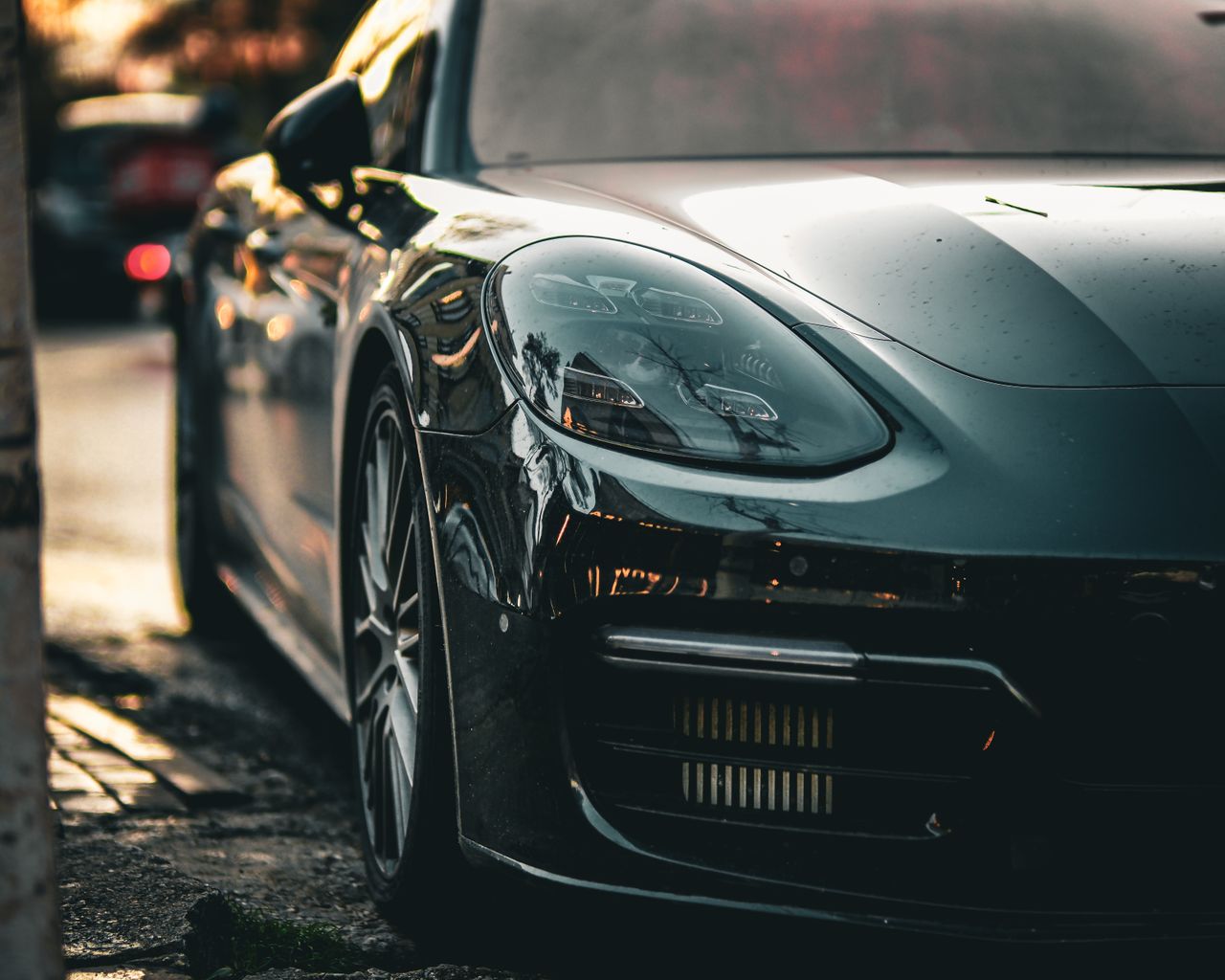 Close-up of a sleek black car parked in Ankara, Türkiye during sunset, highlighting its elegant design.